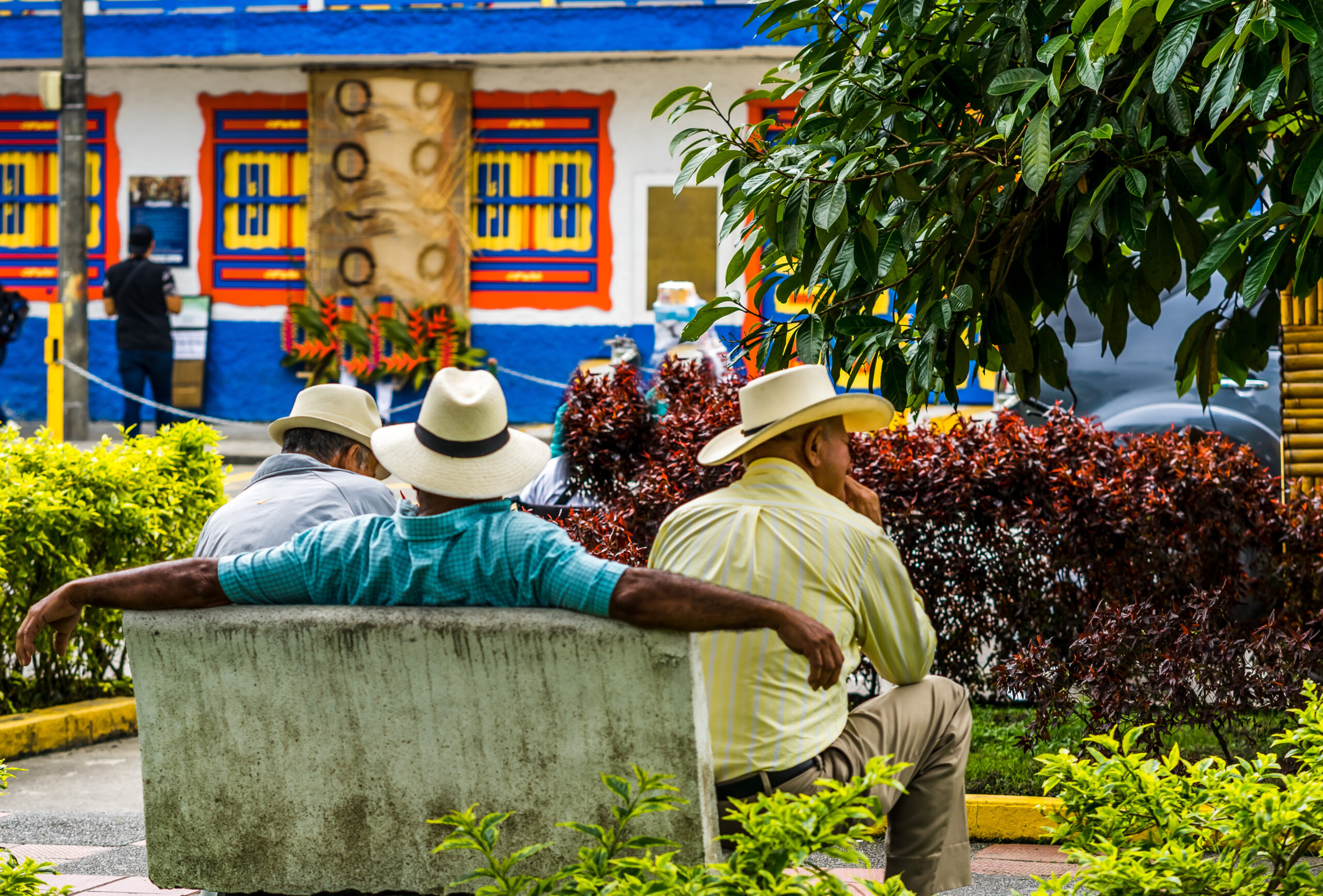 View on people of Colombia, group of old man sitting on bench in the colorful streets of Filandia Village